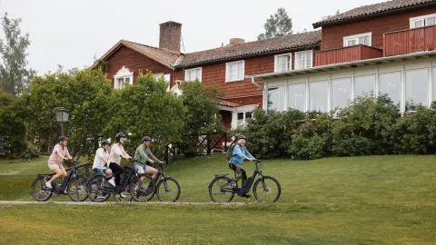 Cyklister utanför hotellbyggnad på Gyllene Hornet.