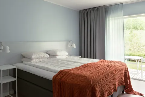 Bäddad dubbelsäng i ett hotellrum. 